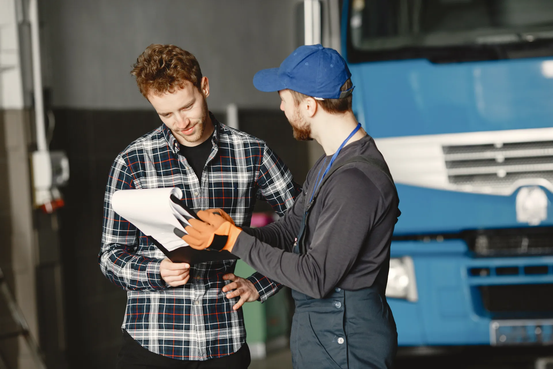 Workers discussing transportation and goods insurance near a truck