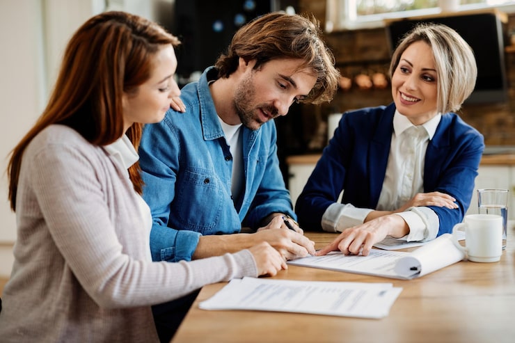 Young couple reviewing documents with an insurance broker during a meeting.