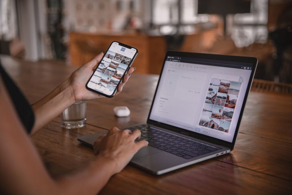 Social media manager reviewing client content on a phone and laptop
